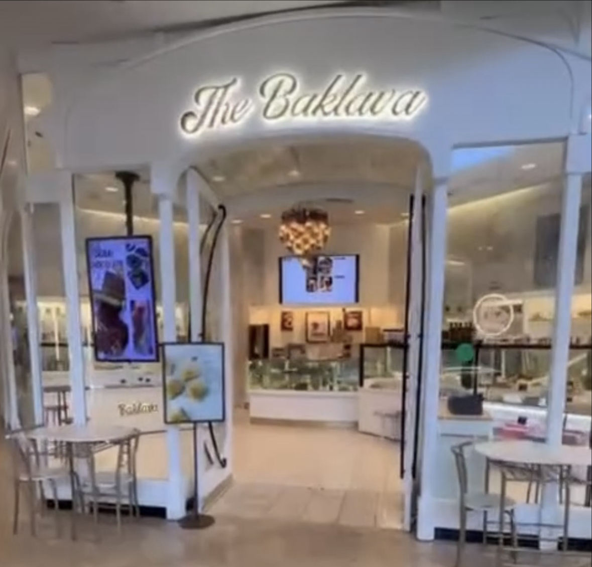 The Baklava storefront at The Shops at Mission Viejo, lit script sign over white archway