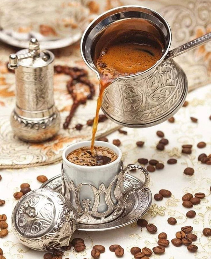 Turkish coffee pouring from an ornate silver cezve into a tulip cup at The Baklava