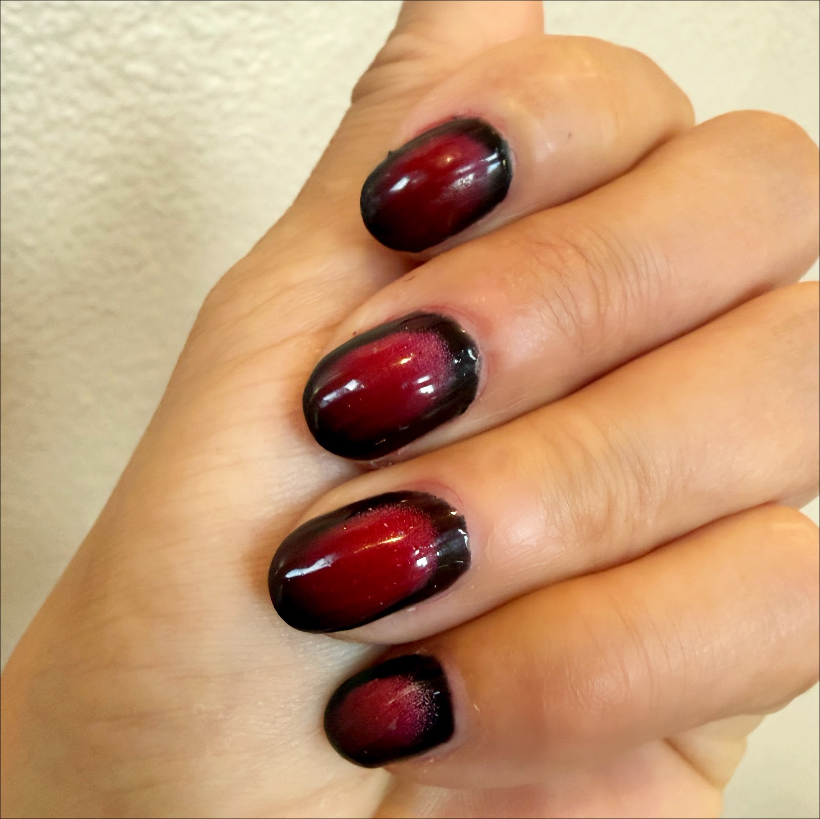 Short oval nails faded from deep red into black