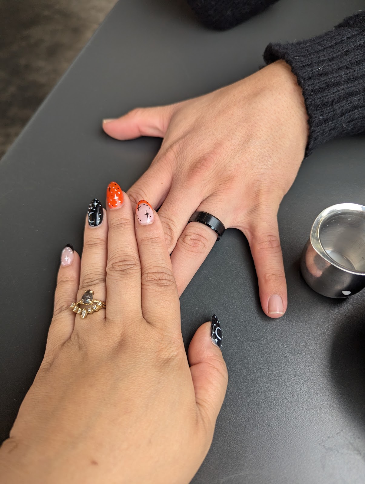 Almond nails with delicate celestial star and moon nail art in black and warm tones