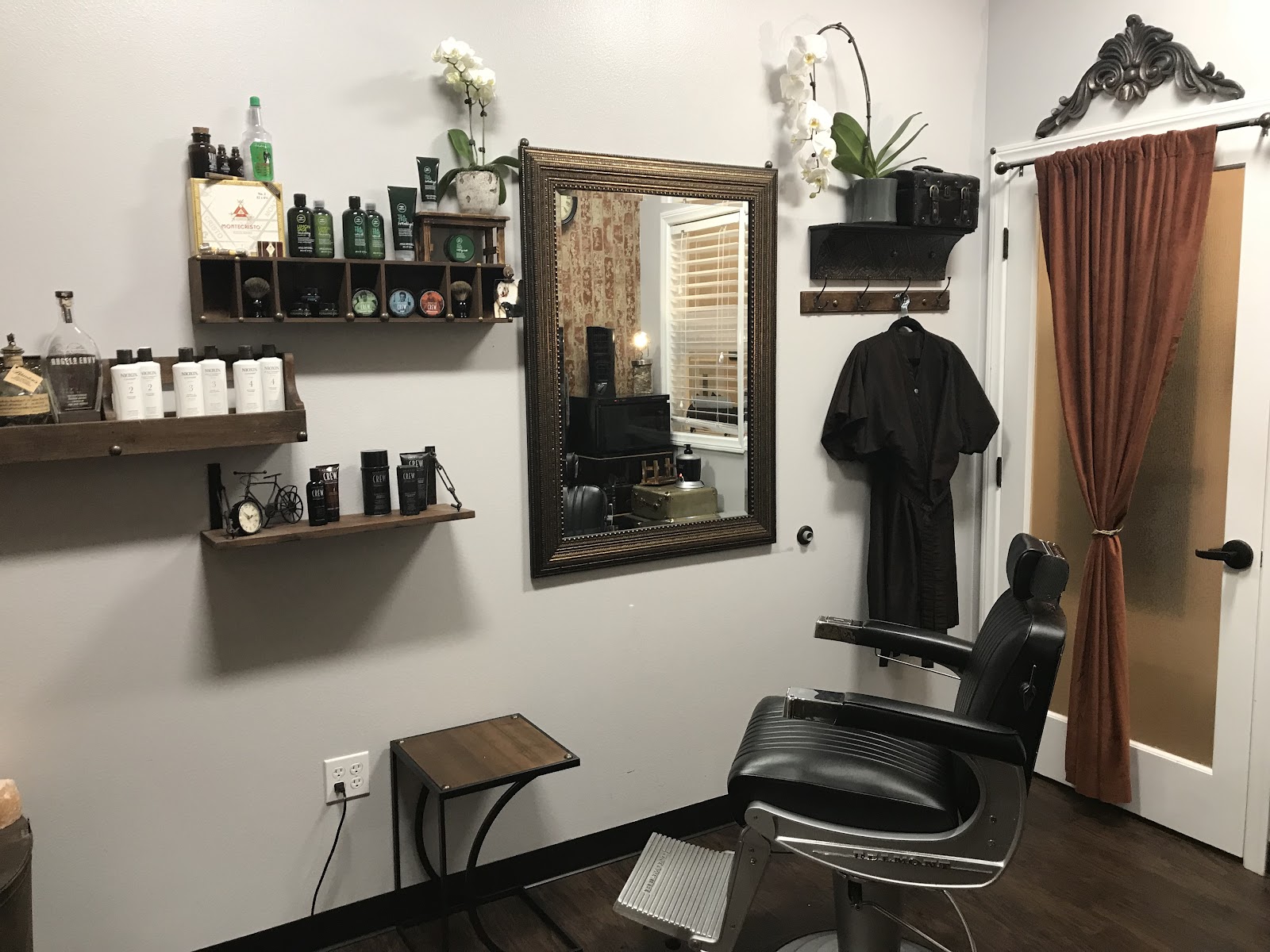 Grooming product shelf, gold mirror, draped curtain and orchids in the suite
