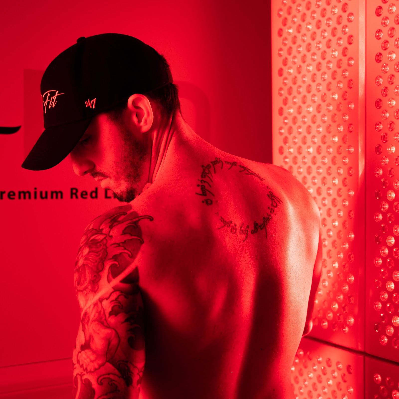 A close-up of the perforated red light panel at the studio with a guest standing in front of it