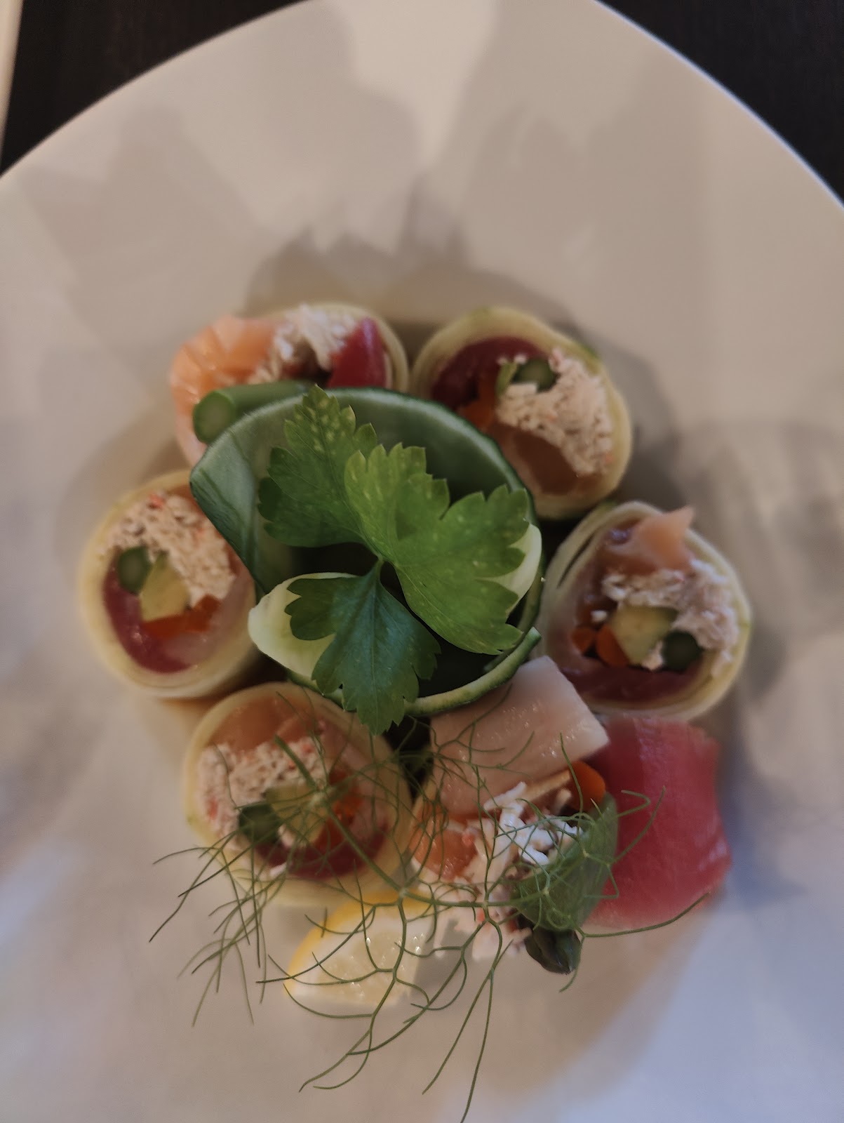 Totoya signature no-rice rolls arranged in a ring on a white plate with cilantro and fennel fronds in the center, San Juan Capistrano