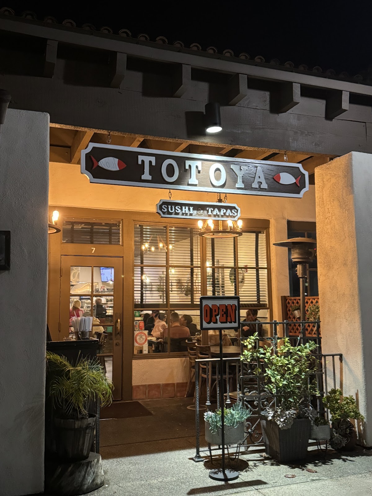 The warm Totoya storefront at night in San Juan Capistrano