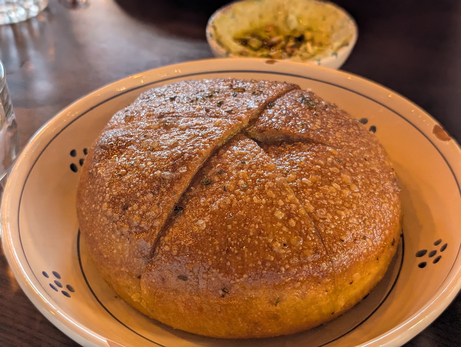 A loaf of focaccia pugliese and bread on the table at Trattoria Trullo